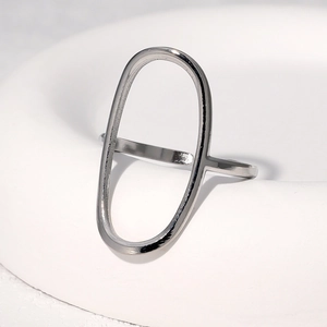 Vue macro d'une bague géométrique ovale creuse minimaliste argentée sur support céramique