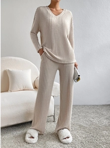Detail of beige knit lounge set featuring V-neck top and ribbed wide leg pants textures