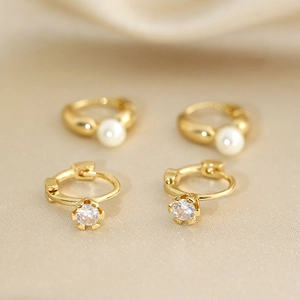 Detailed close-up of gold hoop earrings with elegant pearls and sparkling zircons