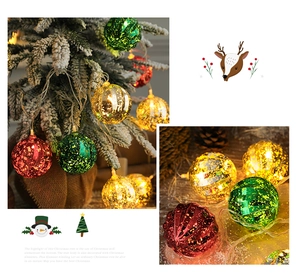 Detail of Christmas bauble fairy lights with gold glitter on a snowy tree