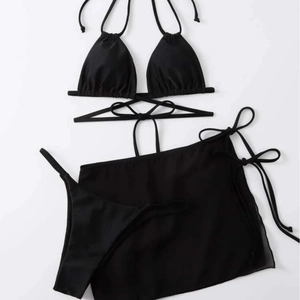 Three-piece black bikini set with wrap-around tie top and matching mesh sarong skirt
