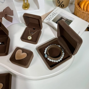 Detailed view of luxury brown velvet jewelry boxes for necklaces and bracelets on a tray