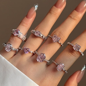 Detailed view of hand wearing various S925 silver rings with pink ice-cut zircon stones