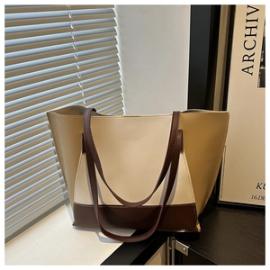 Detail of tricolor leather patchwork tote bag on a white windowsill with modern decor