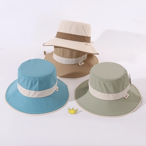 Flat lay of colorful wide brim cotton sun hats for kids in beige, blue and khaki