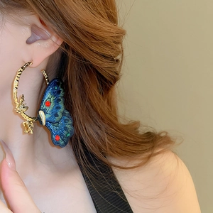 Detail of embroidered blue butterfly hoop earrings with sparkling rhinestones for women