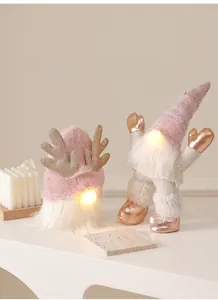 Detail of pink Christmas gnomes with glowing LED lights and sequined antlers decor