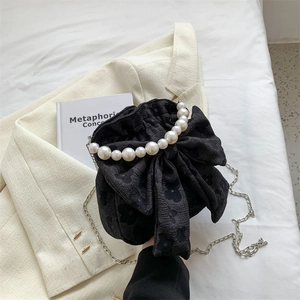 Elegant black jacquard bucket bag with oversized bow and imitation pearl handle strap