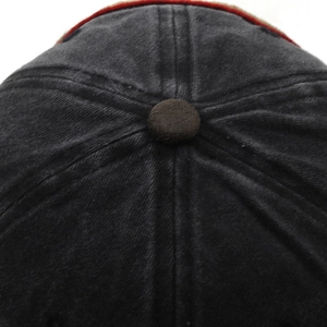 Macro view of washed cotton baseball cap crown with vintage brown button and stitching