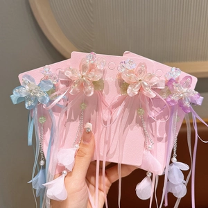 Detail of floral tassel hair clips with resin flowers, pearls and ribbons in soft pastel colors