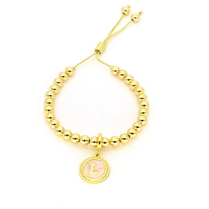 Détail du bracelet à billes dorées avec pendentif lettre L en émail rose et cordon