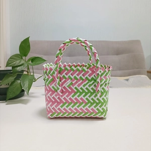 Detailed view of handmade woven basket bag in pink and green diamond pattern