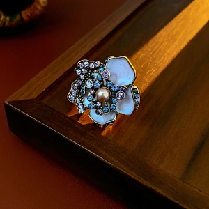 Macro detail of vintage flower stud earring with mother of pearl petals and a pearl center