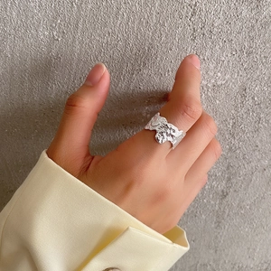 Detailed view of silver S925 ring with irregular wrinkled texture on female finger