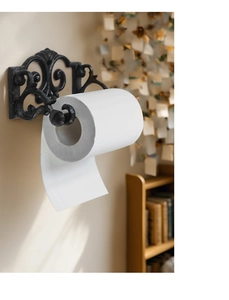 Detail of vintage cast iron wall mount paper towel holder with ornate scroll pattern