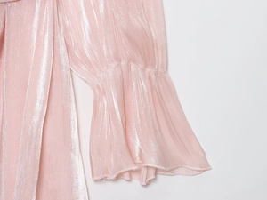 Détail du tissu rose métallisé scintillant avec manche cloche élégante pour femme