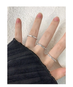 Detail of S925 sterling silver rings with Smile and Lucky engravings worn on fingers