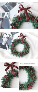 Close-up of Christmas wreath featuring pine needles, red berries, cones, and silk ribbon