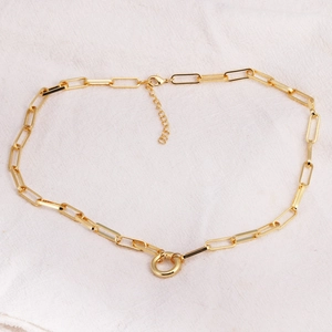 Gold-plated paperclip link necklace featuring a central circular ring pendant and lobster clasp