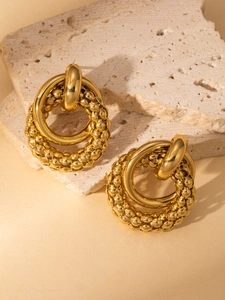 Detail of chunky gold textured hoop earrings showing double layer and beaded design