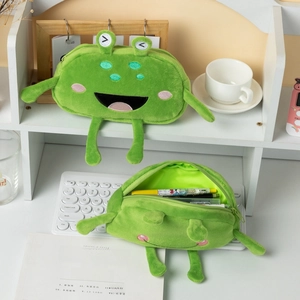 Funny green frog plush pencil case shown on desk with stationery for school storage