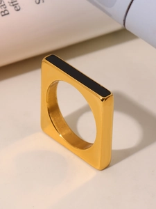 Macro detail of golden stainless steel square ring with black rectangular enamel inlay
