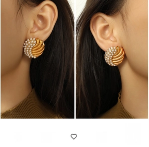 Detailed view of vintage gold wing earrings with pearls and rhinestones on a model