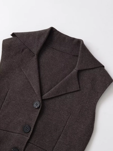 Détail du gilet en tweed marron foncé montrant le col à revers et les boutons noirs