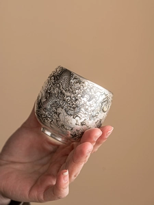 Vue détaillée d'une tasse à thé en argent 999 avec gravure complexe de motif de dragon