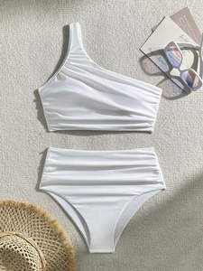 White one-shoulder bikini set with high-waisted ruched bottoms on summer background