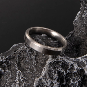 Dettaglio macro dell'anello in acciaio titanio 6mm con bordi smussati lucidi e finitura spazzolata