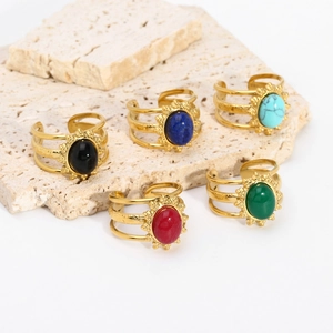 Set of gold-plated stainless steel rings with colorful oval natural stones on stone