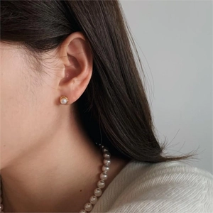 Close-up of model wearing 925 sterling silver pearl stud earrings and necklace