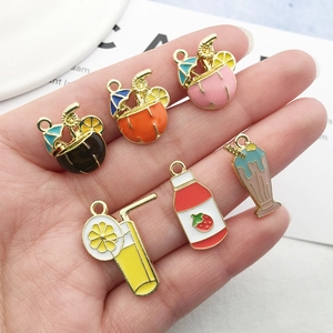 Set of colorful enamel beverage charms for DIY jewelry making held in hand over white card
