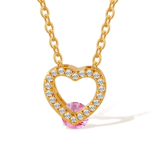 Macro shot of gold-plated heart necklace with pink stone and clear zircon accents
