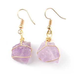 Macro shot of handmade gold wire wrapped natural purple amethyst crystal drop earrings