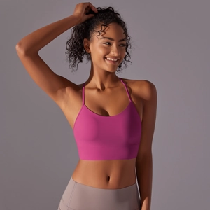 Close-up of rose pink sports bra with thin straps and wide support band on a model