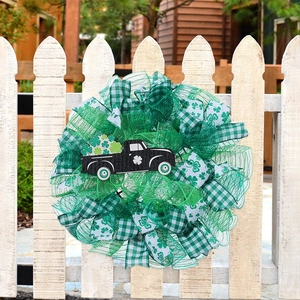 St. Patrick's Day door wreath featuring a black clover truck on a white wooden fence