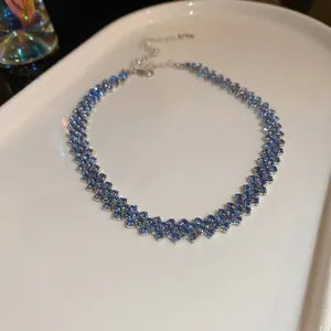 Collana a rombo con zircone blu scintillante e catena argentata su vassoio