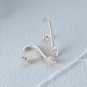 Macro shot of S925 sterling silver snake stud earrings with realistic scale texture