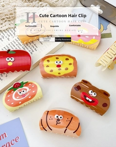 Cute acrylic hair claws featuring cartoon food patterns displayed on lace and book background