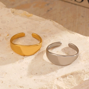 Minimalist open gold and silver stainless steel rings displayed on stone base