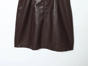 Detailed close-up of stitching and leather texture on a brown crew neck PU dress hem