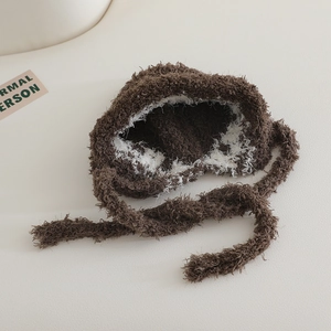 Detailed close-up of fluffy plush earflap hat texture with brown and white faux mink fur