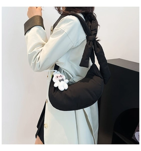 Détail du sac à bandoulière matelassé noir avec nœud géant et breloque lapin mignonne
