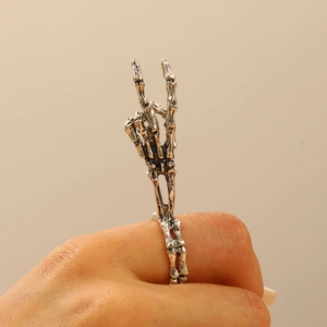 Detailed view of a gothic skull hand ring in vintage silver finish worn on a finger