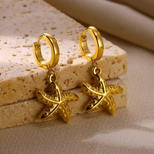Gros plan détaillé des boucles d'oreilles étoile de mer dorées 18 carats sur pierre