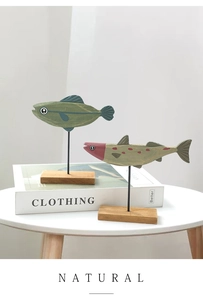 Detail handgefertigter Fisch-Deko aus Holz mit Metallständer auf minimalistischer Basis