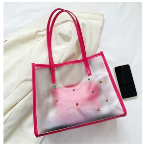 Close-up of pink translucent PVC tote bag with colorful rhinestones and inner pouch