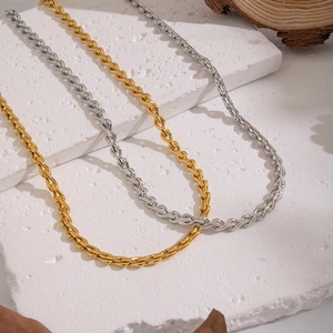 Golden and silver stainless steel geometric twisted chain necklaces on marble